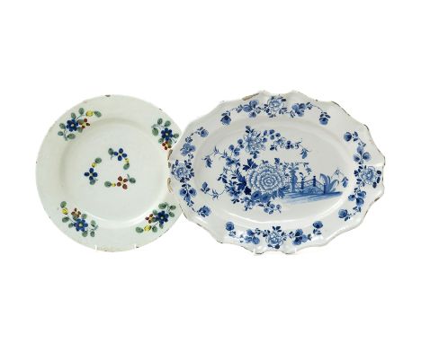 A large English delftware plate  mid 18th century, decorated in the Fazackerly palette with simple scattered flower sprays, a