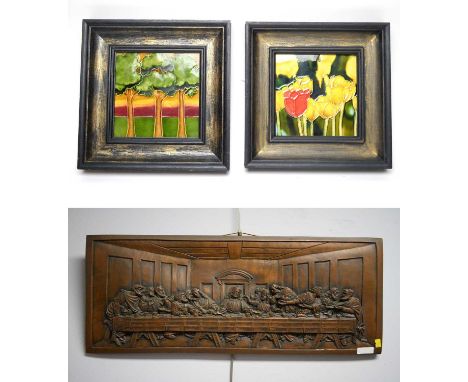 A set of two ceramic wall tiles, tubeline decorated with flowers and trees respectively, in the Moorcroft style, each framed,