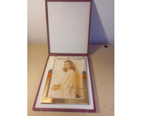 A boxed, polished chrome and gilt frame with royal crestr with a signed portrait. Frame 27.5x27.5cm