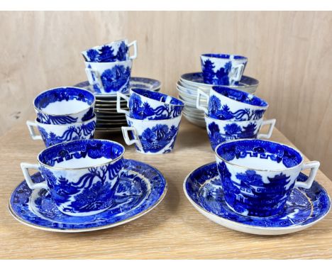 A collection of eleven blue and white willow pattern cups and saucers with side plates. 