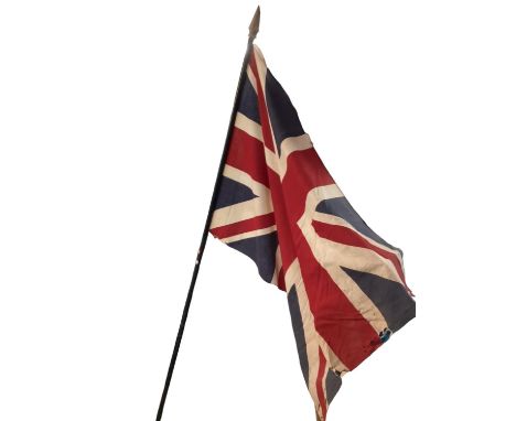A late C19th/early C20th union jack on wooden staff, with pointed finial 224cm long, wear and losses and perishing to the fla
