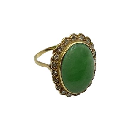 An unmarked yellow metal jade and diamond dress ring, central oval jade cabochon with a surround of single cut diamonds, 2.7 