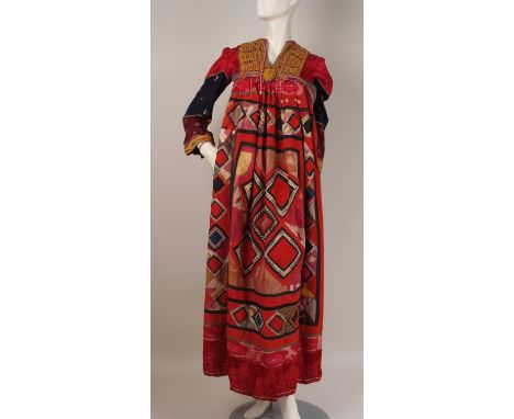 AN AFGHANI WEDDING DRESS. Patch worked in brightly coloured cottons.  Embroidered around the bodice. Bust 28" x 52" Length. (