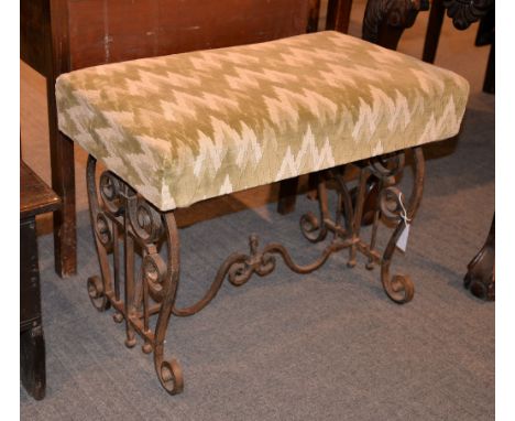 An upholstered piano stool, on associated iron scrollwork base, 53cm high, 70cm wide, 41cm deep