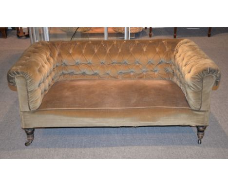 A Victorian Chesterfield sofa with ebonised legs, 146cm wide, and an Edwardian armchair in similar upholstery, 90cm high