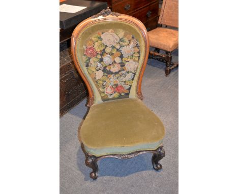 A Victorian carved walnut and floral tapestry and green velvet upholstered spoon back nursing chair, on cabriole feet, 101cm 