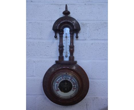 A carved walnut aneroid barometer with thermometer - Height 40cm