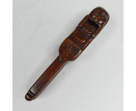 An Early Folk treen Nut Cracker, possibly 17th century, featuring a totem style head in naïve form, scissor action opening an