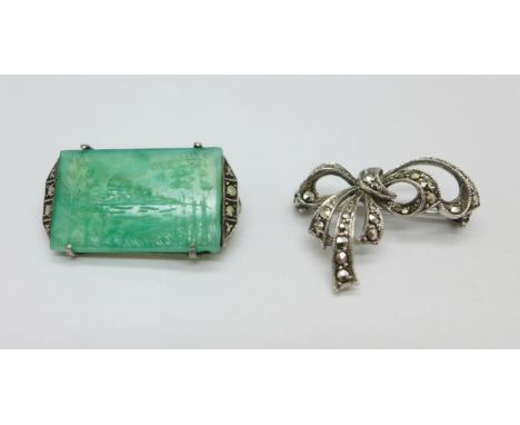 A silver brooch set with a carved jade panel depicting a lake scene with trees, also set with marcasite, and one other brooch