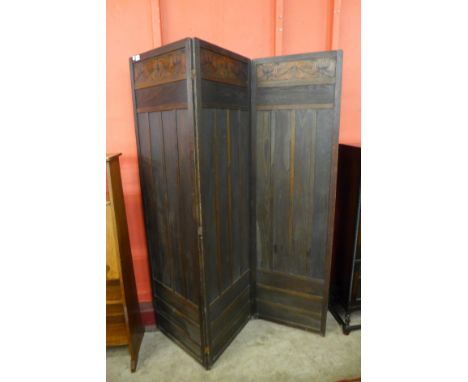 An Arts and Crafts  Liberty &amp; Co. stained oak three panel folding dressing screen 