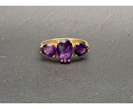 AMETHYST THREE STONE RINGthe central pear cut amethyst approximately 1ct flanked by a smaller pear cut amethyst to each side,