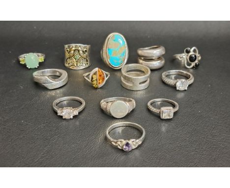 GOOD SELECTION OF THIRTEEN SILVER RINGSincluding a large turquoise set dress ring, a jade coloured hardstone and peridot ring
