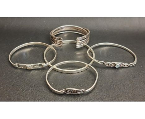 FIVE SILVER BANGLESincluding a multi strand cuff bangle, a blue topaz set bangle with pierced Celtic detail, and two Mackinto