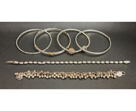 THREE SILVER BANGLES AND THREE SILVER BRACELETSincluding one bangle with gold plated cross detail, a bracelet with silver bea