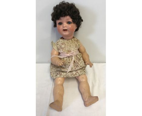 A vintage composite fully jointed doll with teeth and close eye action. Marked Germany to back of head. Shows some signs of r