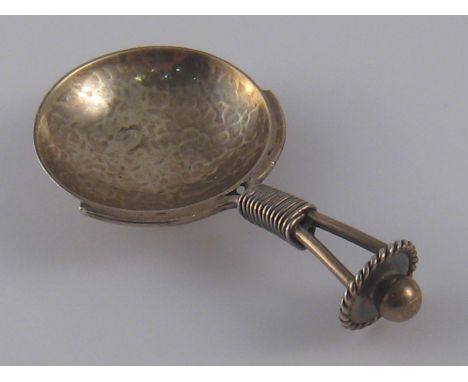 A modern silver caddy spoon with circular bowl and bound wire handle by A.E. Jones, Birmingham, 1920.
