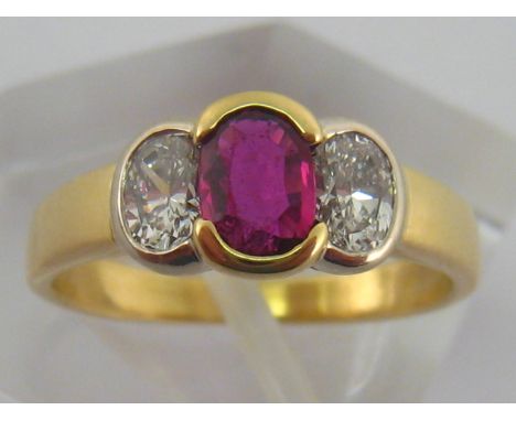 A yellow metal (tests 18 carat gold) ruby and diamond ring, ruby approx 5 x4 mm, the oval diamonds of fine carat and clarity,