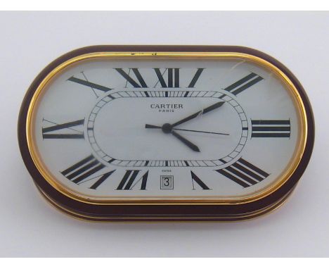 Cartier . A Cartier desk clock with date aperture, quartz movement , marked Cartier Paris and numbered, approx 14cm wide, gla