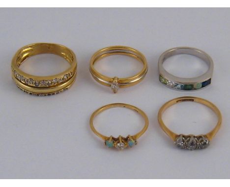 A mixed lot comprising five yellow and white metal (tests 18 carat gold)  rings including a three stone diamond ring, diamond