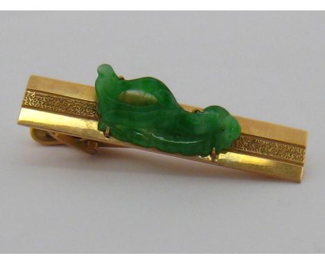 A jadeite tie clip, marked 14k, approx 4.5cm long, jade approx 24mm long, weight 7.5 gms.
