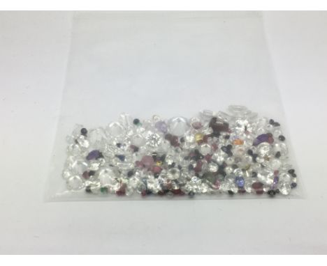 A bag of loose mixed stones including cubic zirconia, emerald, sapphire, garnet, ruby and jade, approx 106.85ct.