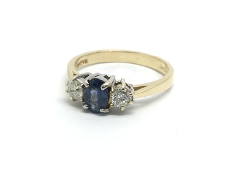 A gold ring set with a central Ceylon sapphire and a diamond to either side, approx .25ct, approx 3g, approx L-M.