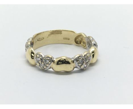 An 18ct gold set with twelve diamonds in a four heart setting, approx 3.1g and approx size K-L.