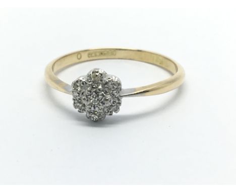 An 18ct gold and platinum seven stone diamond ring in the form of a flowerhead, approx 2.5g and approx size S.