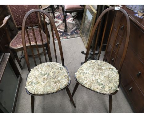 An Ercol drop leaf dining table and a set of six chairs dark wood finish.