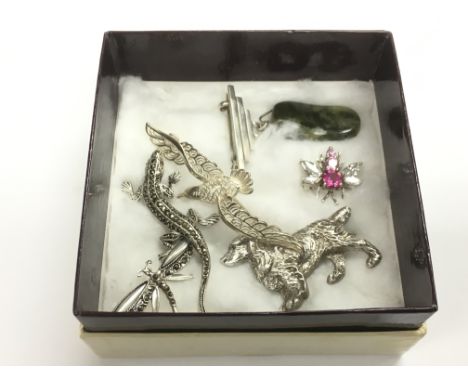 Six silver brooches comprising a jade example, a dragonfly, bird etc.