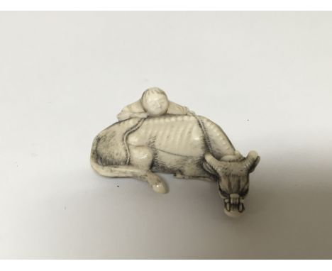 A late 19th century Japanese carved ivory Netsuke. Carved in the form of a buffalo with a figure signed base.