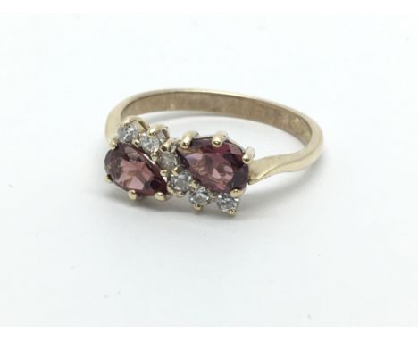 A 9ct gold ring set with two armadine garnets and diamonds, approx 2g and approx size K-L.