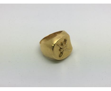 An unmarked gold ring decorated with an unusual emblem, approx 11.9g and approx size L.