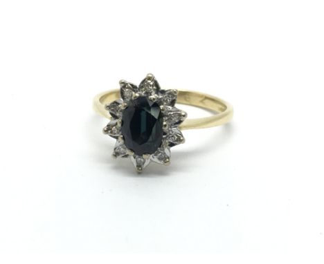 An 18ct gold ring set with a central sapphire and surrounded by diamonds, approx 3.2g and approx size M.