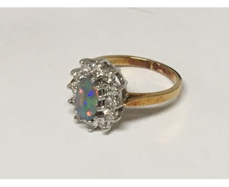 An 18carat gold ring set with an oval opal flanked by brilliant cut diamonds. ring size L.