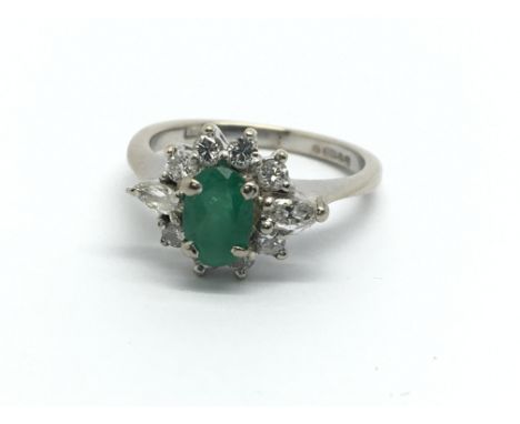 An 18ct white gold emerald and diamond cluster ring, approx 2.6g and approx size F.