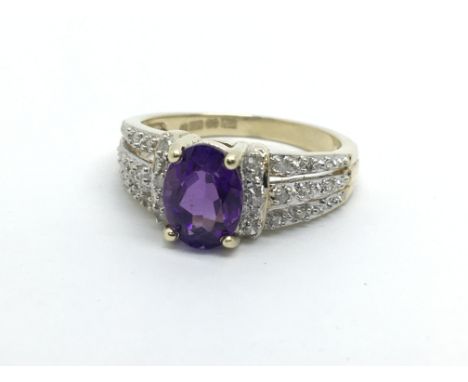 A 9ct gold ring set with a central amethyst and diamonds to the shoulders, approx 2.9g and approx size M.