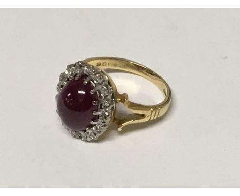 An 18carat gold ring set with a ruby cabochon flanked by diamonds ring size H-I