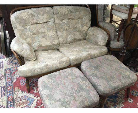 An Ercol modern design lounge suite. With a shaped frame and comprising of a two seater sofa pair of stools and a pair of arm
