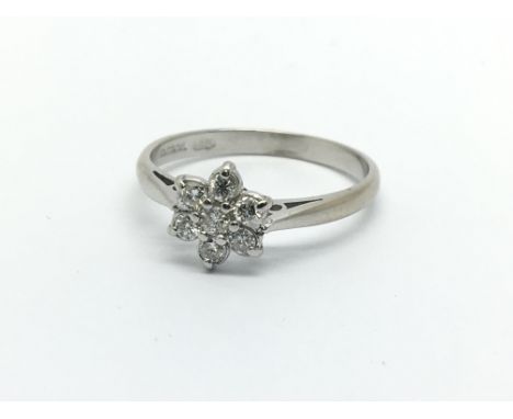 An 18ct white gold seven stone diamond ring in the form of a flowerhead, approx .33ct, approx 2.2g and approx size L.