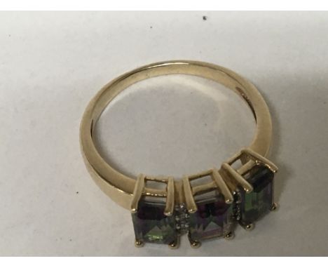 An unmarked gold ring inset with three Alexandrite stones ring size N.