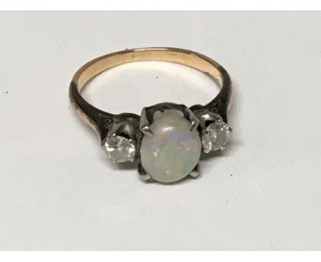 An unmarked gold ring set with an opal flanked by two diamonds ring size J.