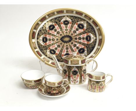 A Royal Crown Derby toyware tea set consisting of teapot, sugar bowl, milk jug, tea cup and saucer on platter