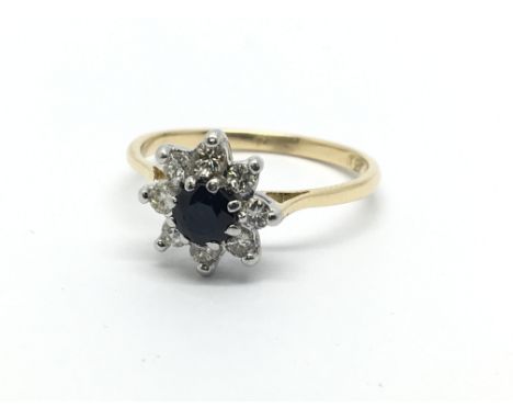 An 18ct gold ring set with a central sapphire and surrounded by diamonds in the form of a flowerhead, approx 2.4g and approx 