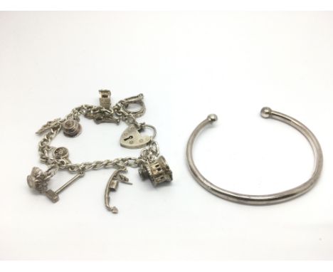 A silver charm bracelet and a silver torque bangle (2).