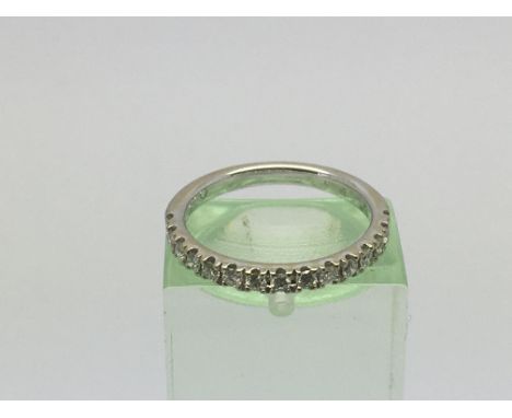 An 18ct white gold half hoop eternity ring set with 15 small round brilliant cut diamonds, total ct weight 0.30ct, clarity S1