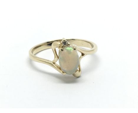 An unmarked gold ring set with an opal and a small diamond, approx 1.9g and approx size K-L.