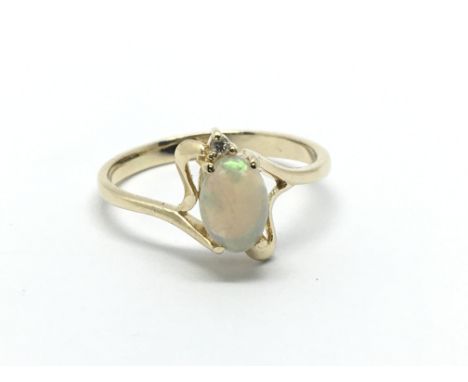 An unmarked gold ring set with an opal and a small diamond, approx 1.9g and approx size K-L.