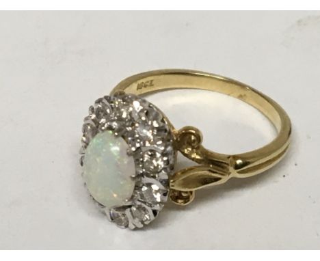 An 18carat gold ring set with an opal and brilliant cut diamond in an oval ring size N.