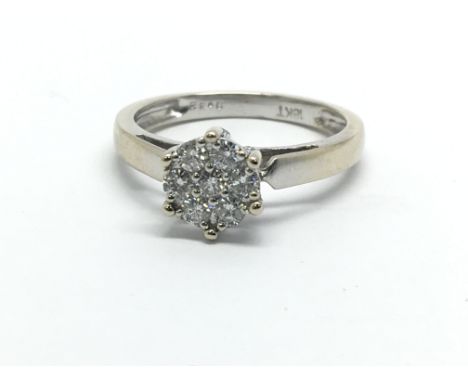 An 18ct white gold diamond cluster ring in the form of a flowerhead, approx .33ct, approx 3.5g and approx size M-N.